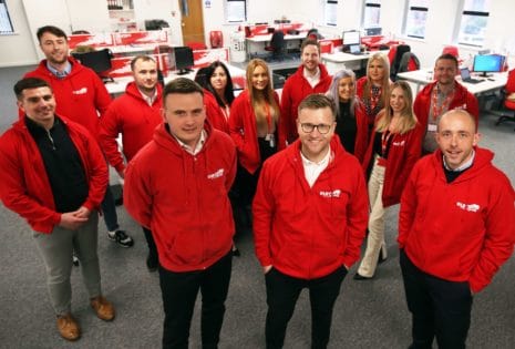The Europa Road team in Newcastle stand together wearing red, branded Europa hoodies