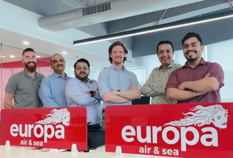 The Europa Air & Sea team in Delhi stand cross armed together smiling to camera.